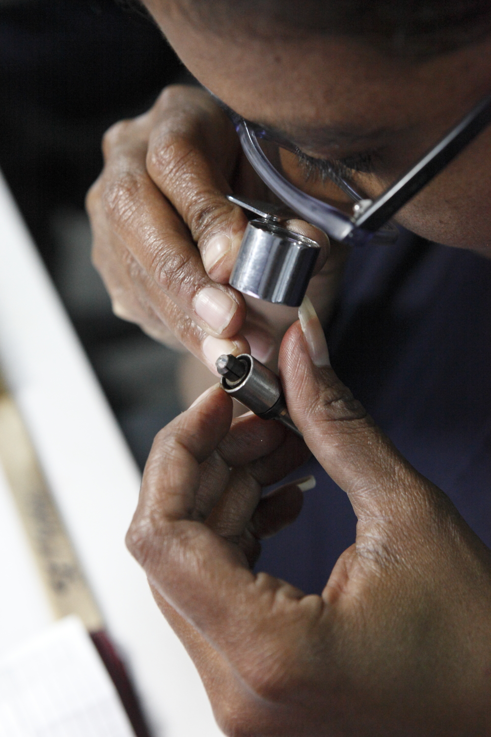 Tiffany diamond getting examined through a diamond Loupe, which is a diamond magnifying glass, at a Tiffany workshop