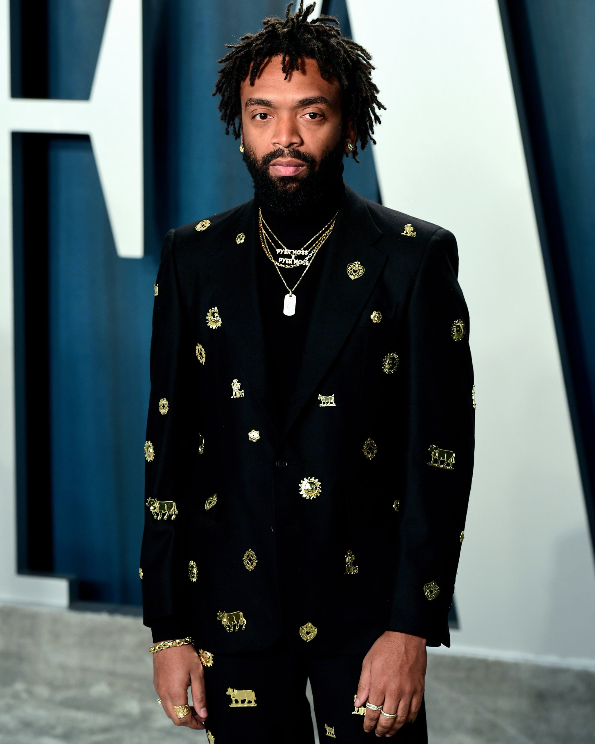 Kerby Jean-Raymond at the 2020 Vanity Fair Oscars Party wearing a custom Bode suit and a mix of diamond nameplate necklaces and a diamond dog tag necklace from Johnny Nelson and John Hardy