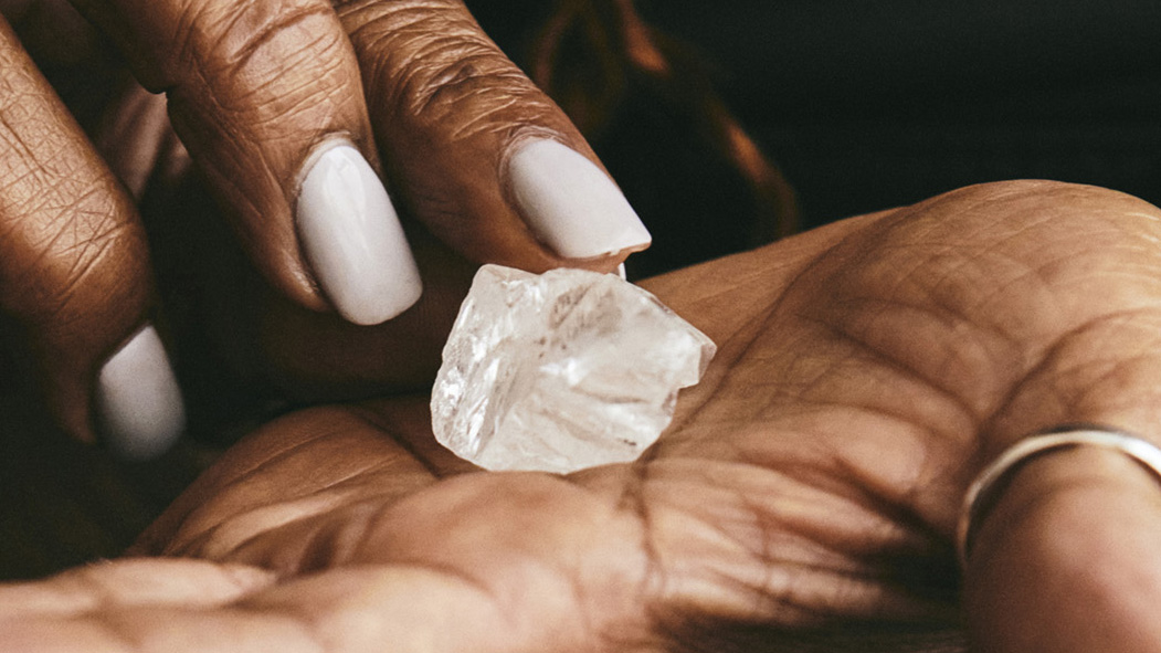 A hand holding a crystal